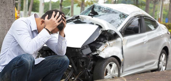 Two vehicles on a roadway with an auto insurance policy document in the foreground